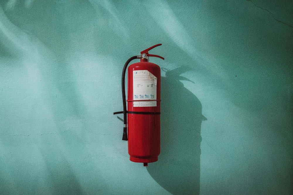 fire extinguisher on green wall